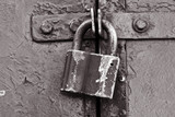 Fototapeta Dmuchawce - Vintage metal lock. black and white film noise effect photo. Classic hanging lock.
