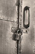 Vintage metal door with old lock. black and white film noise effect photo. Classic hanging lock.