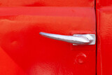 Fototapeta Dmuchawce - Door handle of a retro car close-up. metal lock, door painted red
