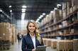 The manager, a woman in a finished goods warehouse with a tablet. Smiling.