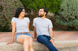Smiling hispanic couple in matching grey t-shirts enjoying a cheerful moment together in a serene garden setting