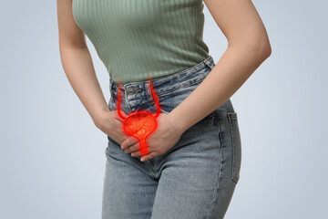 Poster - Woman suffering from cystitis on light background, closeup. Illustration of urinary system