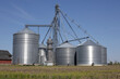 Corn or Grain bins on a farm. Elevators and grain legs direct corn supply to bins. On-farm bins let farmers store surplus.