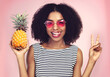 Peace sign, portrait and black woman with pineapple, studio or detox on pink background. Health, nutrition and gut digestion for weight loss and vitamins for female model, vegan and vitamin for fiber