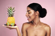 Black woman, studio and beauty with fruit in hand for makeup, tropical food and clean diet with vitamin c. African model girl, nutrition and pink background for health, vegan cosmetics and skin glow