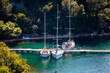 Sailing boats anchored in the Krka river estuary in the close porximity of the town of Skradin, Croatia, hidden by the steep, forest covered cliffs