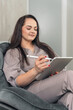 Beautiful young woman sitting in a chair with a digital tablet