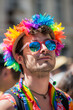 A man wearing a rainbow headband and sunglasses