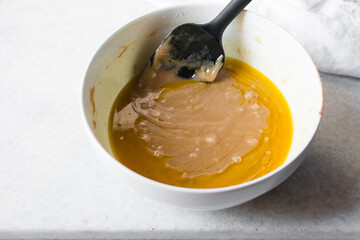 Sticker - Mixing Melted butter and Madeleine batter in a white mixing bowl