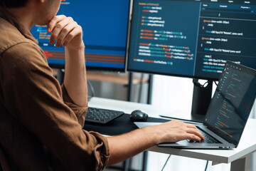 IT developer working online software development on pc monitors at modern home office on coding application screens, creating updated latest program firmware information version concept. Gusher.