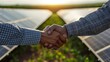 Close-up of a handshake in front of a newly signed solar energy project, financial documents in view