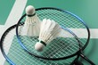 Feather badminton shuttlecocks and rackets on green table, closeup