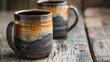 A set of handcrafted mugs featuring rough uneven edges and a glaze that resembles the rugged surface of a mountain..