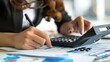 © EarthWalker - Close-up of businesswoman hands using a calculator to check company finances, earnings and budget. Accountant calculating monthly expenses, papers, loan documents, invoices. AI Generated