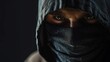 Close-up of a masked bank robber's face, hood casting shadows over his features, set against a stark black background