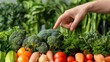 Close-up of a nutritionist's hand pointing at various fresh vegetables during a consultation, patient listening intently