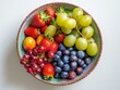 An overhead shot of a colorful fruit bowl on a clean white table.