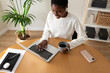 High angle view of young african american woman working at home office. Happy Black female entrepreneur using laptop.