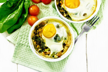 Wall Mural - Scrambled eggs with spinach in bowl on board top