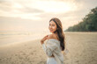 Summer beach vacation concept, Carefree young asian woman relaxing at tropical sea beach during summer vacation, Smiling female enjoying breeze and looking at beach.