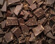 Piles of rich and decadent chocolate fragments scattered in an organized pattern on a seethrough surface