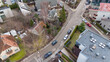 © M - Drone photography of houses and parked cars on a street in a city during spring day