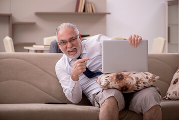 Wall Mural - Old male employee working from home during pandemic