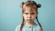 © Nataliia_Trushchenko - A young baby girl with a ponytail and a frowning face. She is wearing a shirt. Portrait of cute little upset girl, naughty kids idea