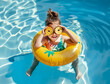 A little girl in the pool is sitting on an inflatable ring and holding two pineapple slices over her eyes