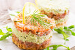 Gourmet salmon fish fruit tartar raw from salmon fillet with chopped avovado as close-up on a white design plate