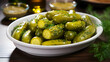 Green pickled marinated gherkins in a white dish