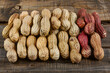 Peanuts with shells of different colors neatly lined up on a wooden table