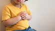 fat kid put yellow tight shirt chest pain severe heartache, heart disease or heart attack. concept healthcare, hospital life insurance concept, doctor day, world hypertension day.