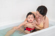 Asian mother and baby girl bathing together in bathtub, Happy lifestyle family concept.