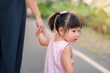 Asian mother walking with daughter in park, Parents hold the baby's hands, Happy family in the park evening light. Happy family concept