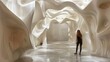 The image is of a woman standing in a white, organic, cave-like structure.
