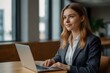 © Abzol - A European young businesswoman using laptop on office.