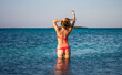 the girl in red bikini in front of a beautiful blue sea