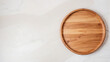 Empty wooden round board on white stone kitchen table top view