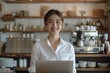 Café Harmony: Asian Manager Smiling with Laptop