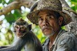 A man wearing a straw hat is holding a monkey