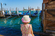 Little girl is watching the gondolas of the Grand Canal on a sunny day in Venice, Italy. San Giorgio Maggiore.