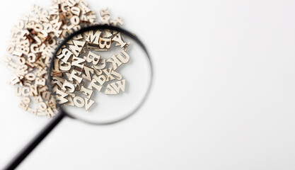 wooden letters english alphabet with lens on white background