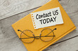 CONTACT US TODAY card with text on a yellow notepad