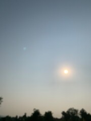 Wall Mural - Blurred image of the sun rising in the sky