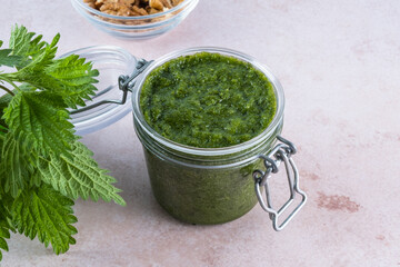 Dandelion greens pesto in jar on a gray background, top view. Appetizer, condiment or topping. Healthy vegan food. 