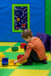 Portrait of a cute little boy in a colorful entertainment room background.