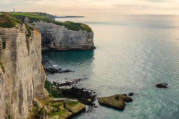 Wall Mural - White chalk natural cliffs in Etretat, Normandy, France. French sea coast in Normandie with famous rock formations at sunset. Travel and touristic destination