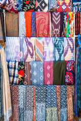 Poster - Traditional silk Asian scarves with a bright colorful pattern at the oriental bazaar in Tashkent in Uzbekistan