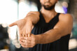 © Prostock-studio - Young Man Performing Wrist Stretching Exercise in a Gym Setting